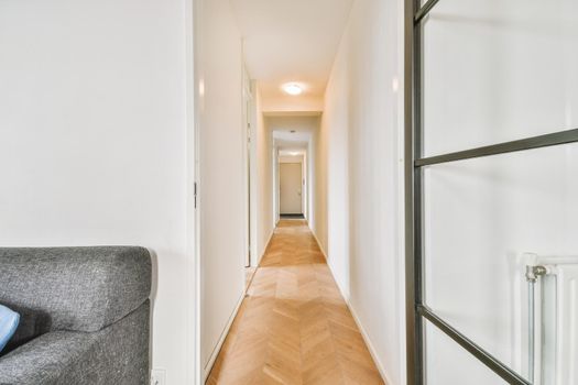 Interior of contemporary flat in minimal style with spacious hallway with white walls