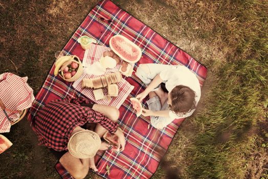 Couple in love enjoying picnic time drink and food in beautiful nature on the river bank top view