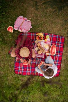 Couple in love enjoying picnic time drink and food in beautiful nature on the river bank top view