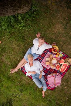 Couple in love enjoying picnic time drink and food in beautiful nature on the river bank top view