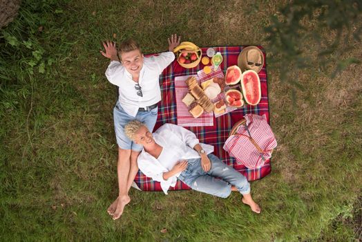 Couple in love enjoying picnic time drink and food in beautiful nature on the river bank top view