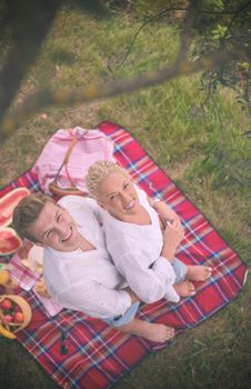 Couple in love enjoying picnic time drink and food in beautiful nature on the river bank top view