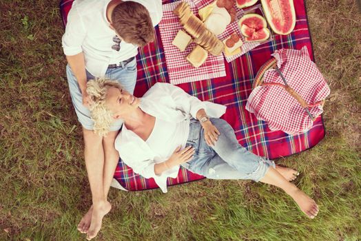 Couple in love enjoying picnic time drink and food in beautiful nature on the river bank top view