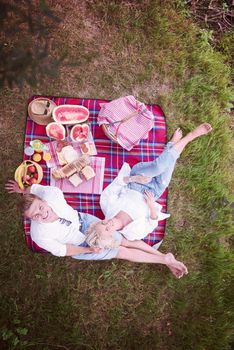 Couple in love enjoying picnic time drink and food in beautiful nature on the river bank top view