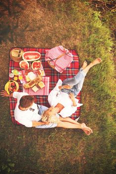 Couple in love enjoying picnic time drink and food in beautiful nature on the river bank top view