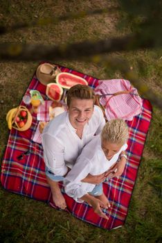 Couple in love enjoying picnic time drink and food in beautiful nature on the river bank top view