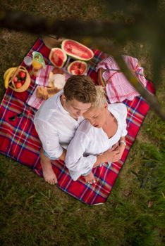 Couple in love enjoying picnic time drink and food in beautiful nature on the river bank top view