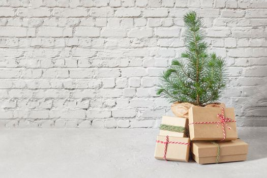 small New Year tree with Christmas gift boxes on the brick wall background, zero waste concept