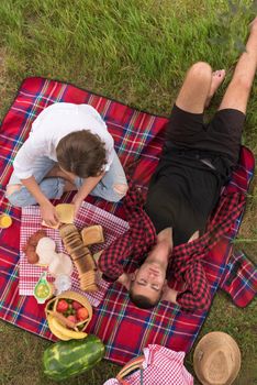 Couple in love enjoying picnic time drink and food in beautiful nature on the river bank top view