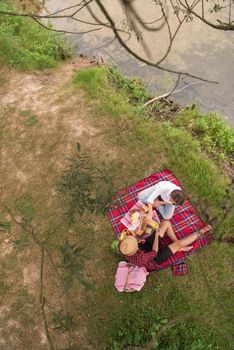 Couple in love enjoying picnic time drink and food in beautiful nature on the river bank top view