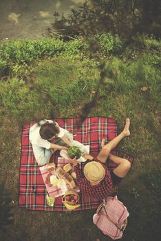 Couple in love enjoying picnic time drink and food in beautiful nature on the river bank top view