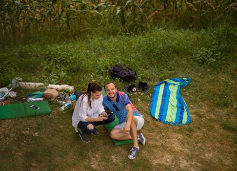 Couple in love enjoying picnic time drink and food in beautiful nature on the river bank