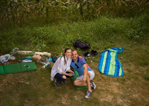 Couple in love enjoying picnic time drink and food in beautiful nature on the river bank