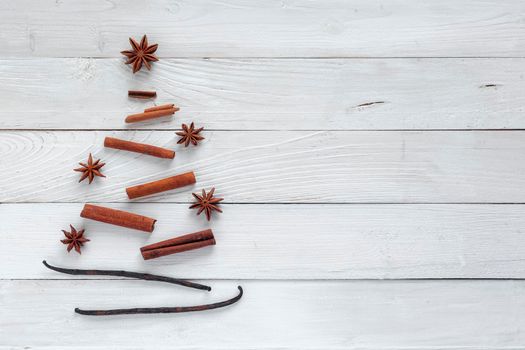 New Year spice tree made of cinnamon sticks, vanilla pods and anis star, minimalism style,, white wooden background, top view