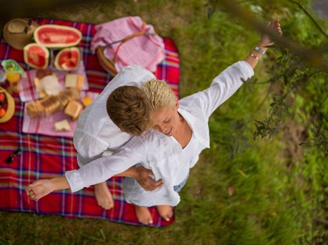 Couple in love enjoying picnic time drink and food in beautiful nature on the river bank top view