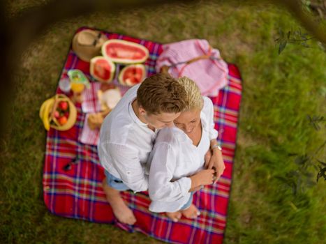 Couple in love enjoying picnic time drink and food in beautiful nature on the river bank top view