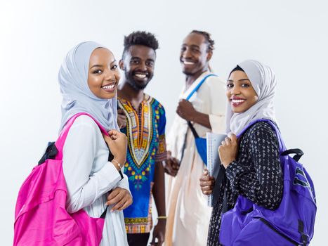 group portrait  of happy african students standing together against white background girls wearing traidiional sudan muslim hijab fashion
