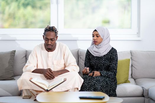 african muslim couple at home in ramadan reading quran holly islam book
