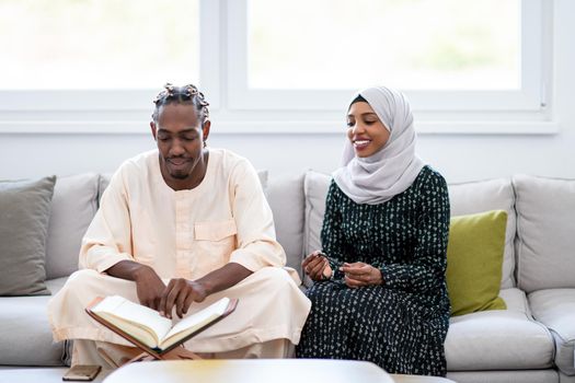 african muslim couple at home in ramadan reading quran holly islam book