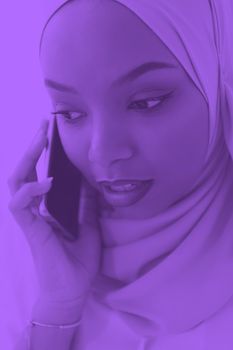 african business woman using smartphone wearing hijab clothes pink duotone