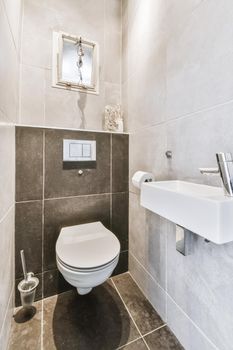 Stylish washroom with black tiled floor and wall-hung toilet