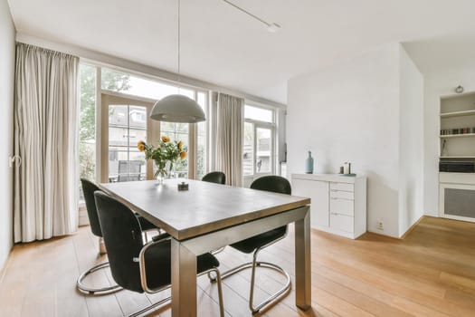 Dining area with stylish table and comfortable soft black chairs