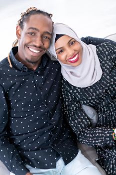 African Couple Sitting On Sofa Watching TV Together Chroma Green Screen Woman Wearing Islamic Hijab Clothes
