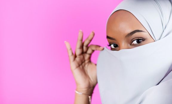 portrait of young modern muslim afro beauty wearing traditional islamic clothes on plastic pink background