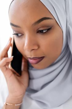 young modern muslim african business woman using smartphone wearing hijab clothes isolated on white background