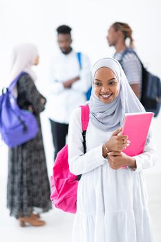 african female student with group of friends in background  wearing traditional Islamic hijab clothes