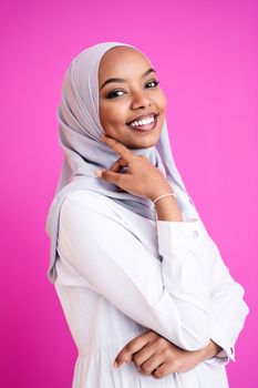 portrait of young modern muslim afro beauty wearing traditional islamic clothes on plastic pink background