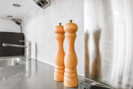 Graceful salting and pepper shaker on a black countertop in a luxury kitchen