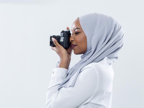 young  african modern muslim woman using retro camera wearing hijab clothes isolated on white background