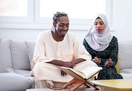 african muslim couple at home in ramadan reading quran holly islam book