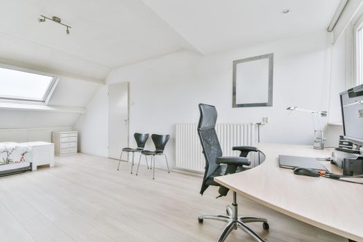 Working area in a large room with a leather comfortable black chair