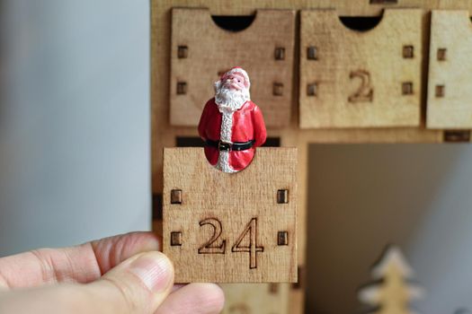 Hand opens wooden advent calendar