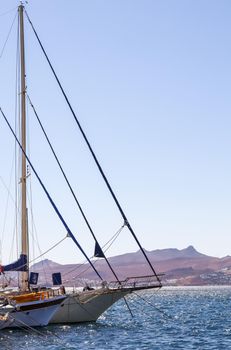 Sailboats in the blue sea against the backdrop of islands and mountains. Sports and summer vacations concept