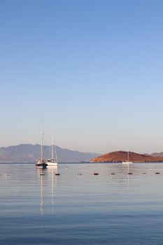 Beautiful sunrise on the Aegean Sea with islands, mountains and boats. High quality photo