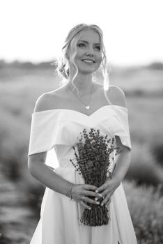 the bride in a white dress walks on the lavender field