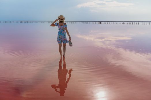 girl posing at sunset on the famous pink salt lake. reflection in the lake.