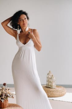 a woman in a white sundress in a bright interior. The concept of relaxation.