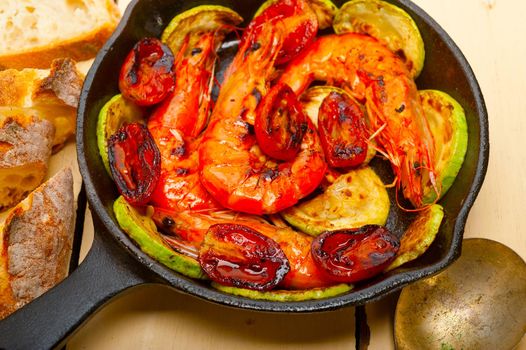 roasted shrimps on cast iron skillet  with zucchini and tomatoes