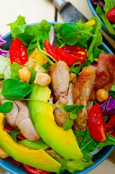 fresh and healthy Chicken Avocado salad over rustic wood table