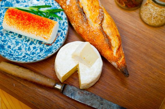 French cheese and fresh  baguette on a wood cutter