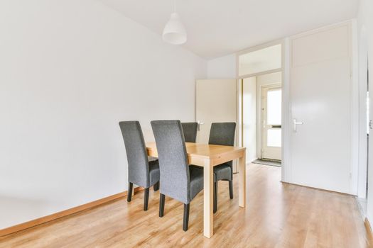 Spacious dining room table and chairs in modern apartment in minimal style