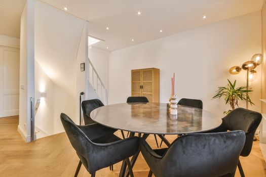 Stylish and cozy dining area with a round black table and black chairs