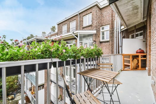 Elegant narrow and long balcony with wooden table and chairs