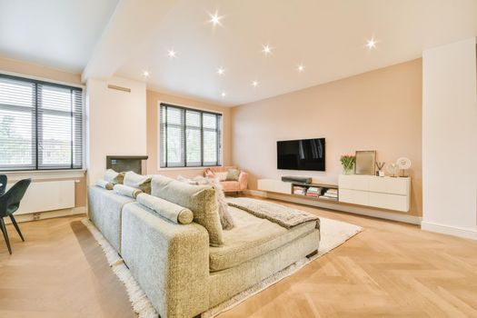 Stylish and cozy living room with soft green soft huge sofa