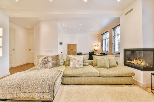 Stylish and cozy living room with soft green soft huge sofa