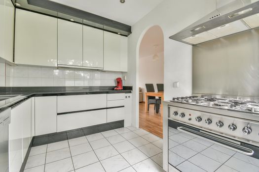 Interior of the light kitchen with modern appliances in a modern flat at daytime